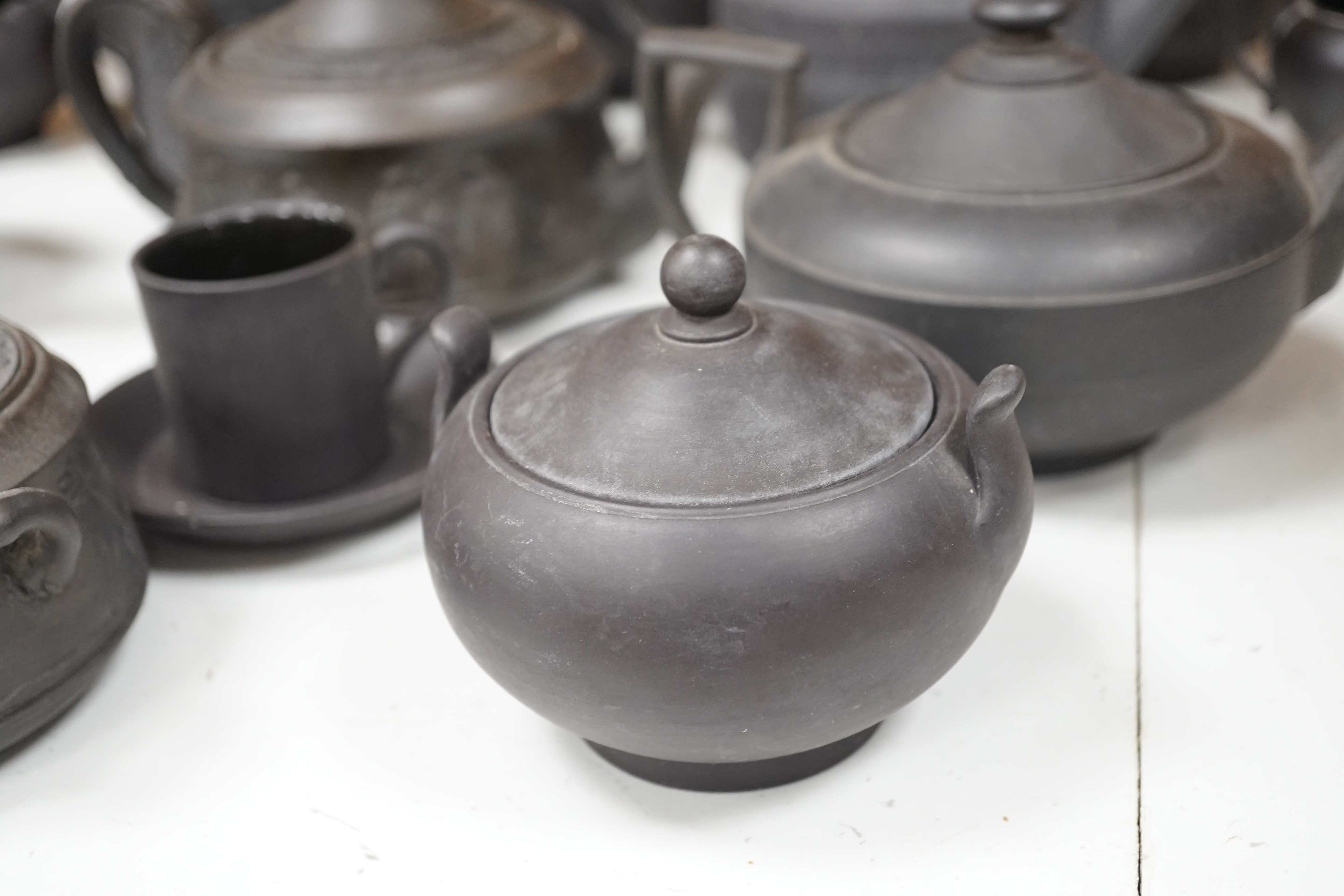 A collection of Wedgwood and other black basalt teapots and tea wares, 19th/early 20th century, tallest teapot 17cms high